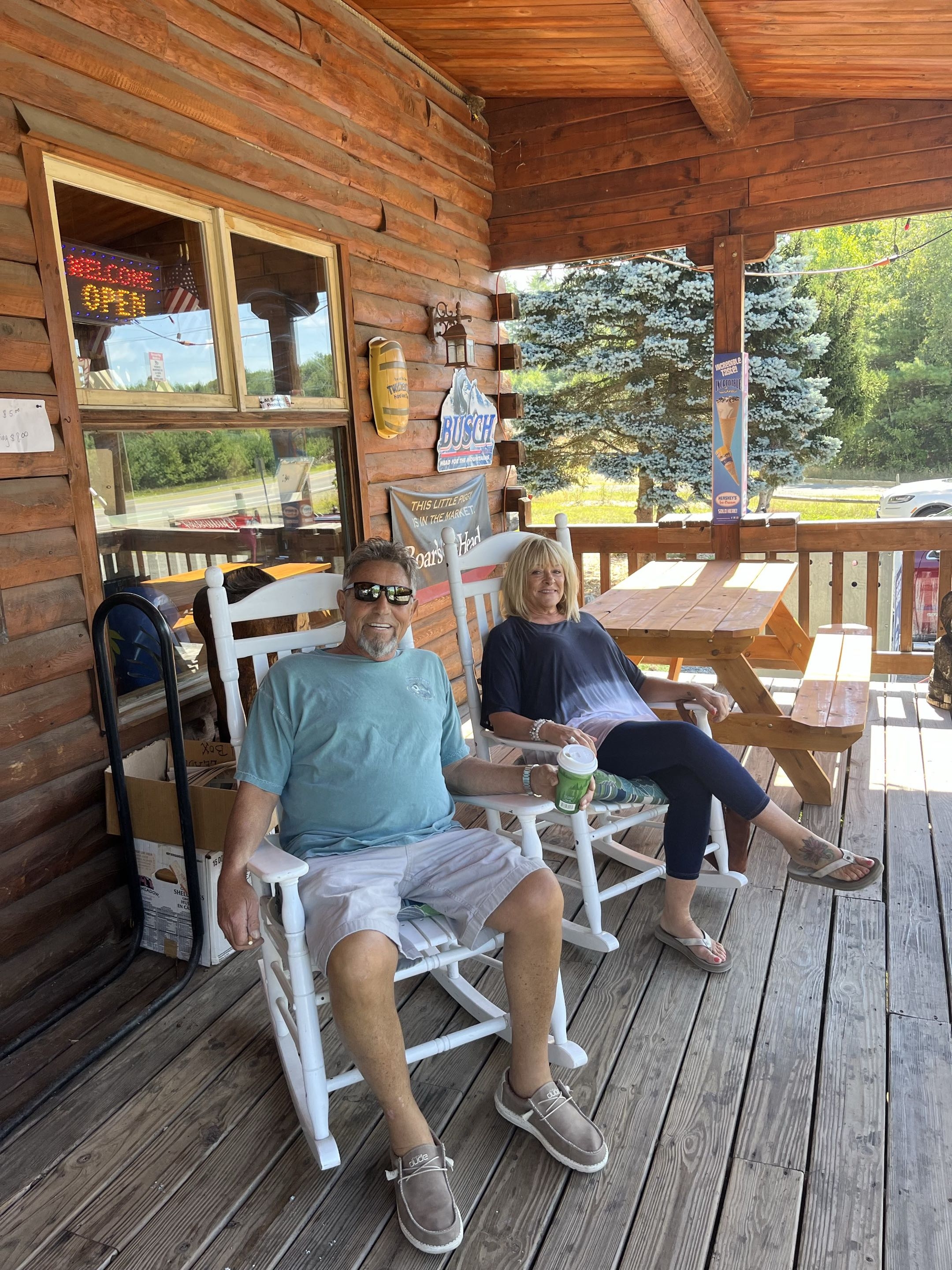 Couple relaxing on the porch in rocking chairs at Swiftwater Way Station